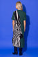 Alden Adair Scout Dress in forest green with bold black-and-white zebra silhouette graphic, back view on model with black boots.