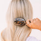 Teleties Mini Detangler Hair Brush in tortoise pattern being used to brush long blonde hair.