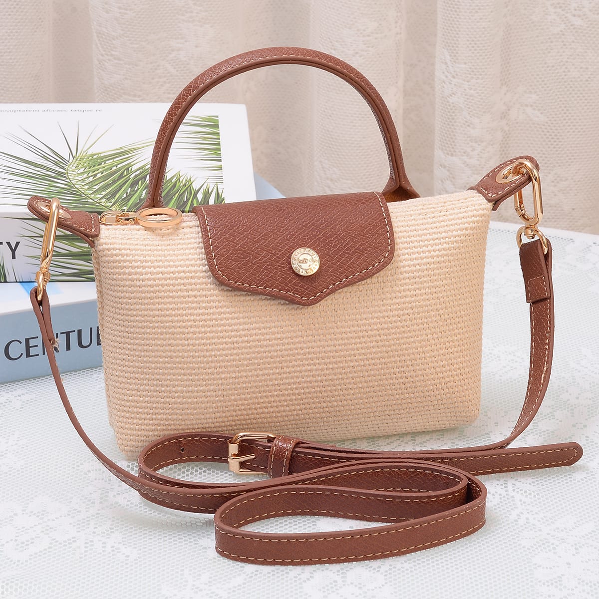 Lacey Straw Mini crossbody bag with woven body, brown leather flap closure, top handle, and adjustable shoulder strap.
